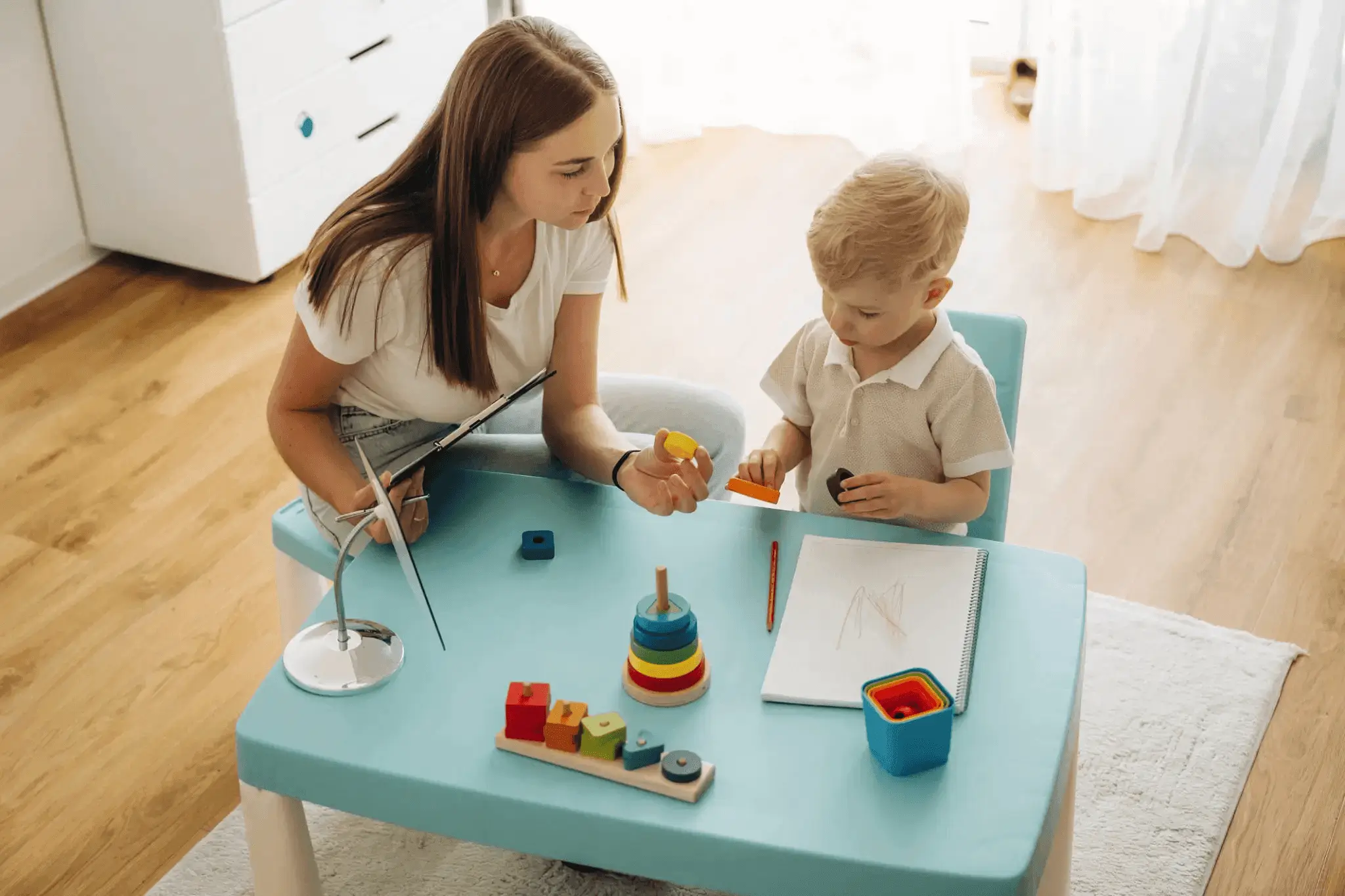 Adult and child playing with educational toys.